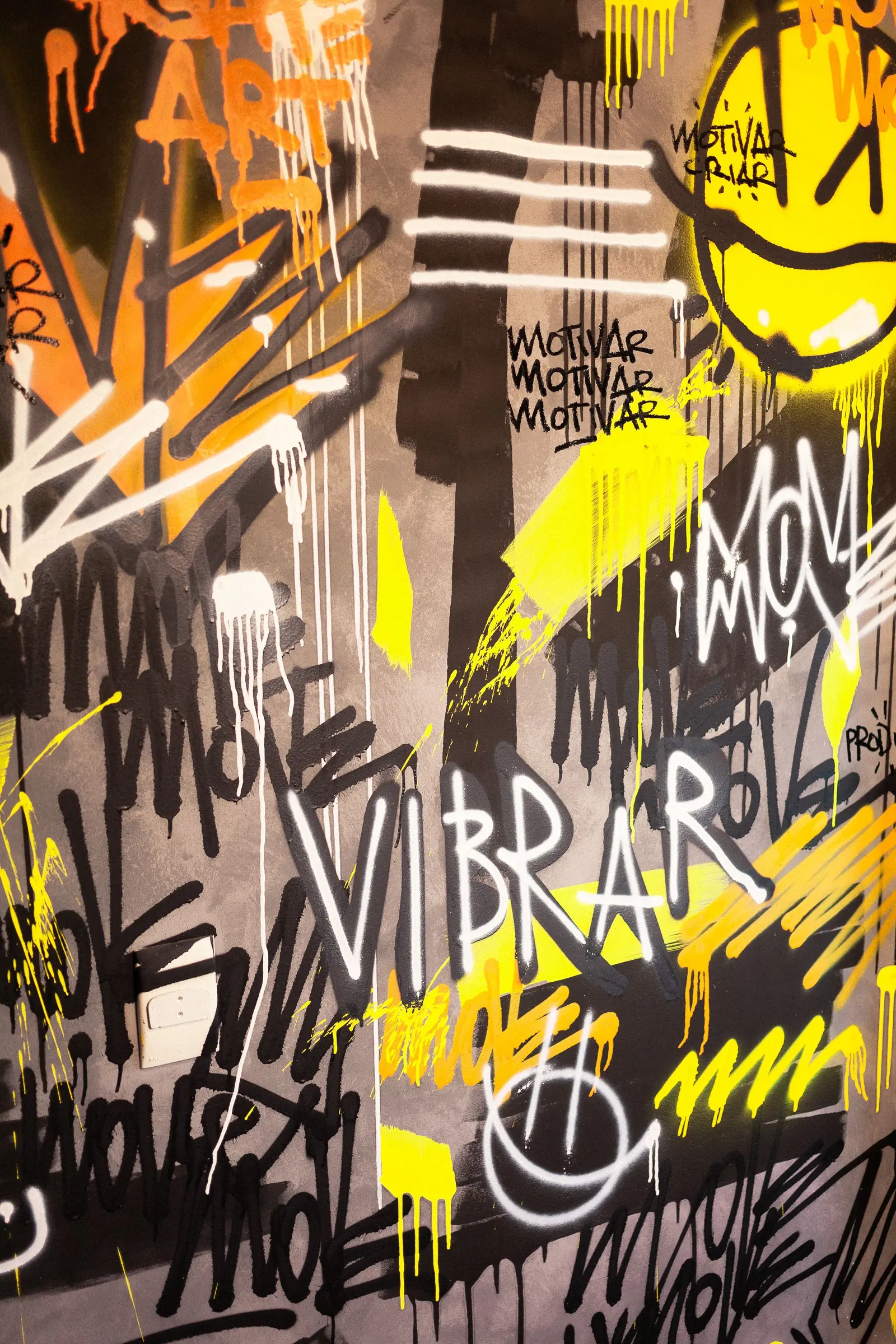Muro con grafiti amarillo y negro que dice VIBRAR